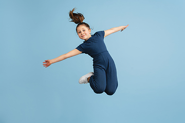 Image showing Pretty caucasian girl portrait isolated on blue studio background with copyspace