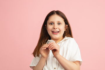 Image showing Pretty caucasian girl portrait isolated on pink studio background with copyspace