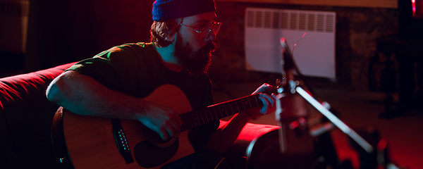 Image showing Close-up of musician performing in neon light. Concept of advertising, hobby, music, festival, entertainment.