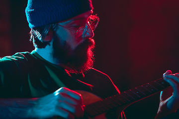 Image showing Close-up of musician performing in neon light. Concept of advertising, hobby, music, festival, entertainment.