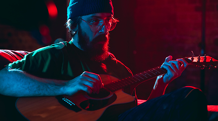 Image showing Close-up of musician performing in neon light. Concept of advertising, hobby, music, festival, entertainment.