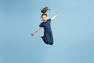 Image showing Pretty caucasian girl portrait isolated on blue studio background with copyspace