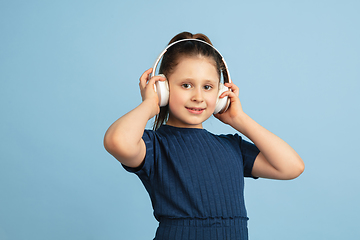 Image showing Pretty caucasian girl portrait isolated on blue studio background with copyspace