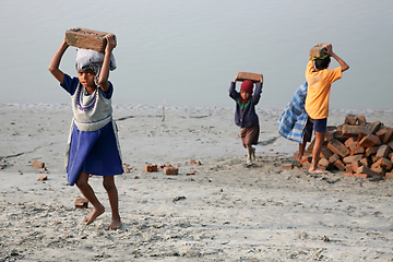 Image showing Child workers carry bricks carrying it on his head in Sonakhali, West Bengal, India