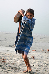 Image showing Child workers carry bricks carrying it on his head in Sonakhali, West Bengal, India