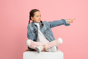 Image showing Happy kid, girl isolated on pink studio background. Looks happy, cheerful, sincere. Copyspace. Childhood, education, emotions concept