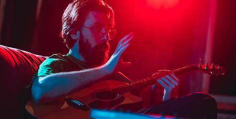 Image showing Close-up of musician performing in neon light. Concept of advertising, hobby, music, festival, entertainment.