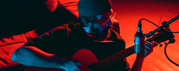 Image showing Close-up of musician performing in neon light. Concept of advertising, hobby, music, festival, entertainment.