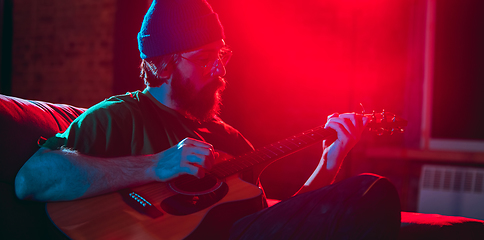 Image showing Close-up of musician performing in neon light. Concept of advertising, hobby, music, festival, entertainment.