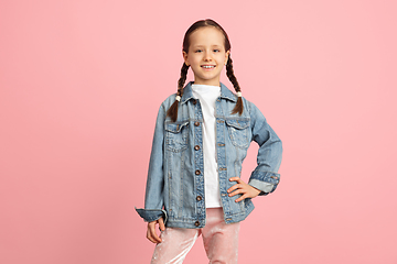 Image showing Happy kid, girl isolated on pink studio background. Looks happy, cheerful, sincere. Copyspace. Childhood, education, emotions concept