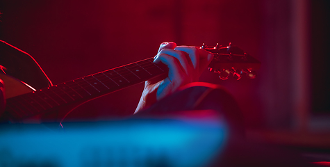 Image showing Close-up of musician performing in neon light. Concept of advertising, hobby, music, festival, entertainment.