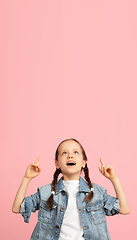 Image showing Happy kid, girl isolated on pink studio background. Looks happy, cheerful, sincere. Copyspace. Childhood, education, emotions concept