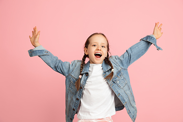 Image showing Happy kid, girl isolated on pink studio background. Looks happy, cheerful, sincere. Copyspace. Childhood, education, emotions concept