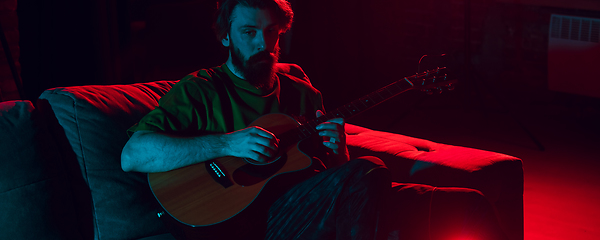 Image showing Close-up of musician performing in neon light. Concept of advertising, hobby, music, festival, entertainment.