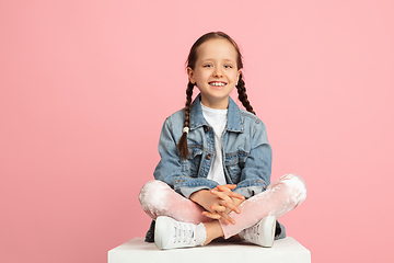 Image showing Happy kid, girl isolated on pink studio background. Looks happy, cheerful, sincere. Copyspace. Childhood, education, emotions concept