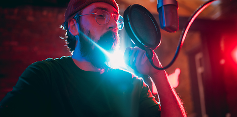 Image showing Close-up of musician performing in neon light. Concept of advertising, hobby, music, festival, entertainment.