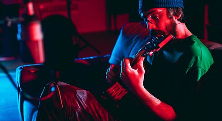 Image showing Close-up of musician performing in neon light. Concept of advertising, hobby, music, festival, entertainment.