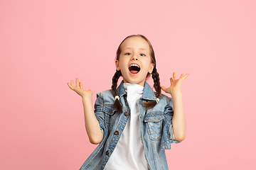 Image showing Happy kid, girl isolated on pink studio background. Looks happy, cheerful, sincere. Copyspace. Childhood, education, emotions concept