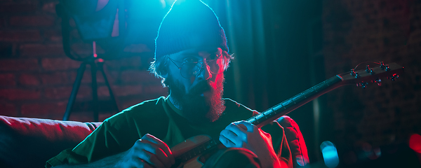 Image showing Close-up of musician performing in neon light. Concept of advertising, hobby, music, festival, entertainment.