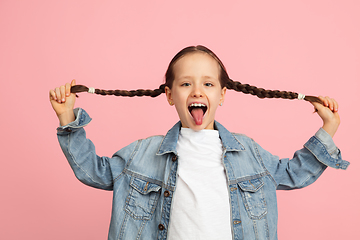 Image showing Happy kid, girl isolated on pink studio background. Looks happy, cheerful, sincere. Copyspace. Childhood, education, emotions concept