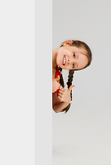 Image showing Happy kid, girl isolated on white studio background. Looks happy, cheerful, sincere. Copyspace. Childhood, education, emotions concept