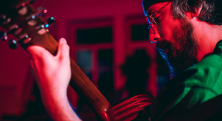 Image showing Close-up of musician performing in neon light. Concept of advertising, hobby, music, festival, entertainment.