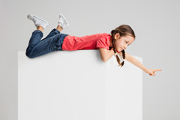 Image showing Happy kid, girl isolated on white studio background. Looks happy, cheerful, sincere. Copyspace. Childhood, education, emotions concept