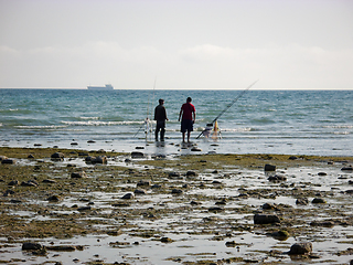 Image showing Fishermen on the seashore.