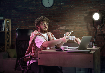 Image showing Young happy Caucasian man doing shopping online through laptop.