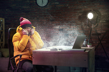 Image showing Young man in bright yellow puffy jacket meeting winter on virtual video call.