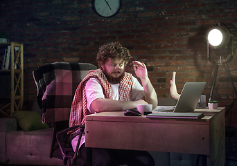 Image showing Young Caucasian man talking with friend online through laptop.