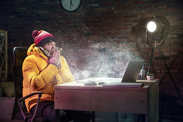 Image showing Young man in bright yellow puffy jacket meeting winter on virtual video call.