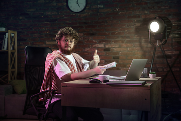 Image showing Young happy Caucasian man doing shopping online through laptop.