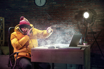 Image showing Young man in bright yellow puffy jacket meeting winter on virtual video call.