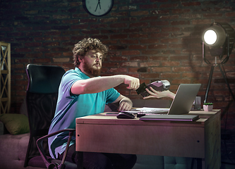 Image showing Young happy Caucasian man doing shopping online through laptop.