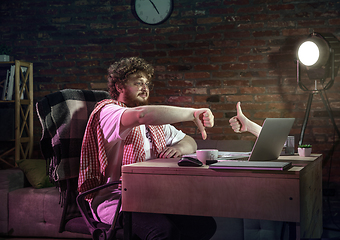 Image showing Young Caucasian man talking with friend online through laptop.