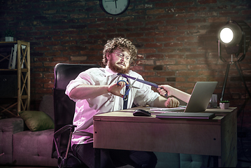 Image showing Young Caucasian man working at home online through laptop. Virtual reality.