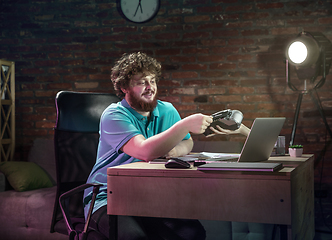 Image showing Young happy Caucasian man doing shopping online through laptop.