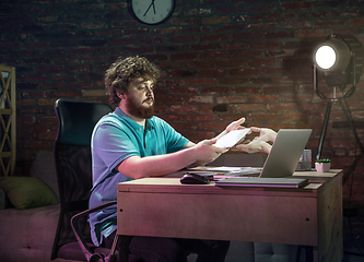 Image showing Young happy Caucasian man doing shopping online through laptop.