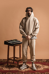 Image showing Full-length portrait of man, musician isolated on light yellow background.