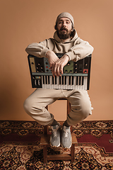 Image showing Full-length portrait of man, musician isolated on light yellow background.