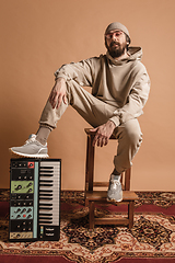 Image showing Full-length portrait of man, musician isolated on light yellow background.