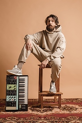 Image showing Full-length portrait of man, musician isolated on light yellow background.