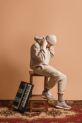 Image showing Full-length portrait of man, musician isolated on light yellow background.