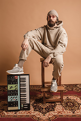 Image showing Full-length portrait of man, musician isolated on light yellow background.