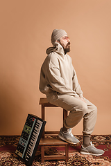 Image showing Full-length portrait of man, musician isolated on light yellow background.