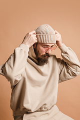 Image showing Portrait of Caucasian man in glasses and hat isolated on light background.