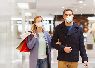 Image showing couple in medical masks with shopping bags in mall