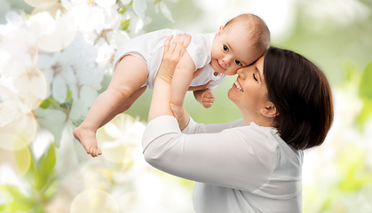 Image showing happy mother with baby over cherry blossoms