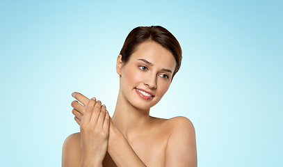 Image showing woman applying moisturizing cream to her hand